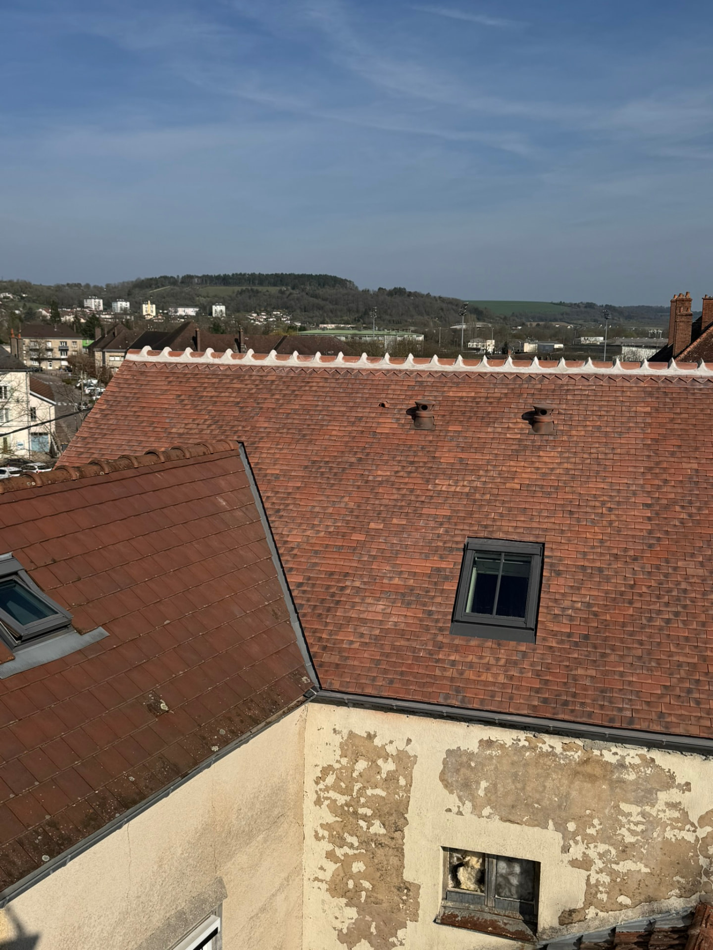Toiture rénovée en tuiles plates avec fenêtre de toit