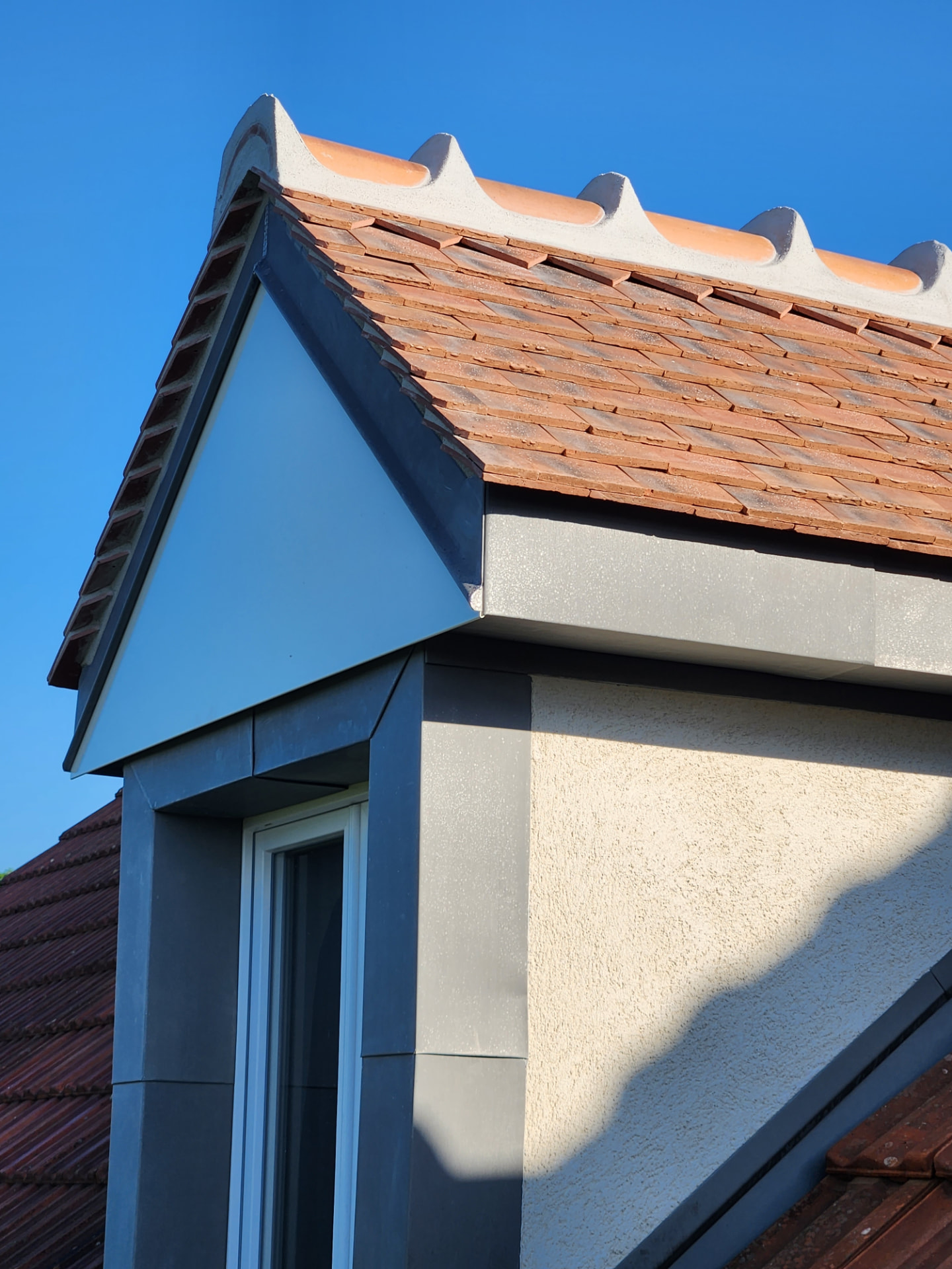 Lucarne habillée en zinc sur toiture en tuiles